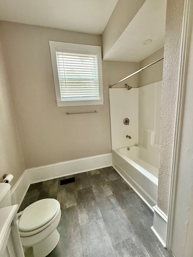 bathroom featuring toilet, bathtub / shower combination, and hardwood / wood-style flooring