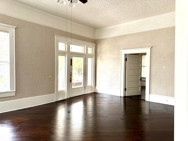 entrance foyer featuring ornamental molding, dark wood-type flooring, and a textured ceiling