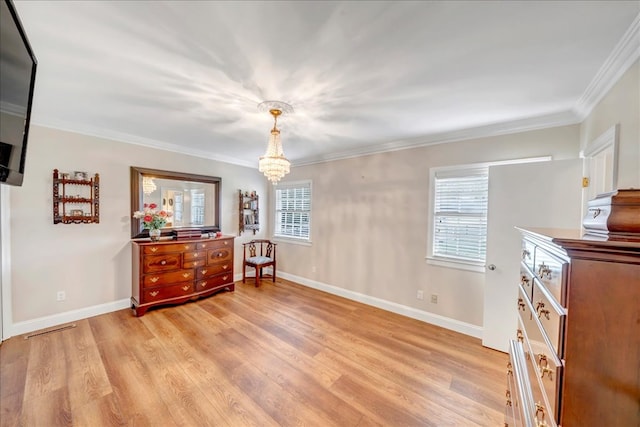 interior space with light wood-type flooring, a chandelier, and ornamental molding