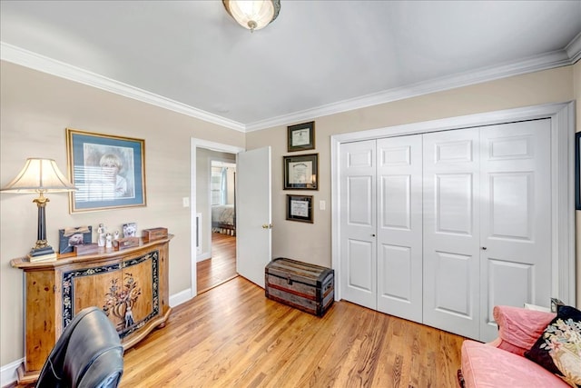 living area with light hardwood / wood-style floors and crown molding