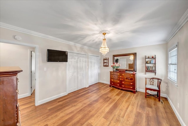 living area featuring crown molding, light wood-type flooring, and an inviting chandelier