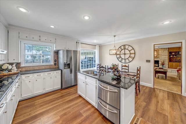 kitchen featuring sink, white cabinetry, and stainless steel fridge