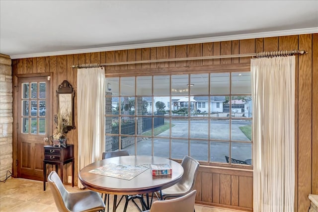 dining area featuring ornamental molding and wooden walls