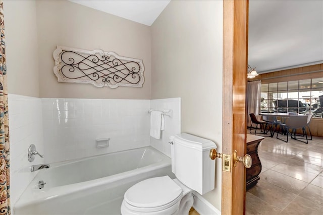 bathroom featuring toilet, a washtub, and tile patterned flooring