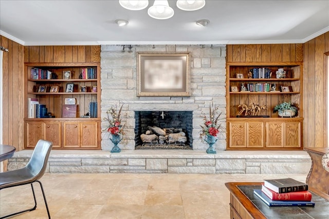 living room with built in features, wood walls, and ornamental molding