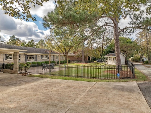 view of property's community featuring an outdoor structure and a lawn