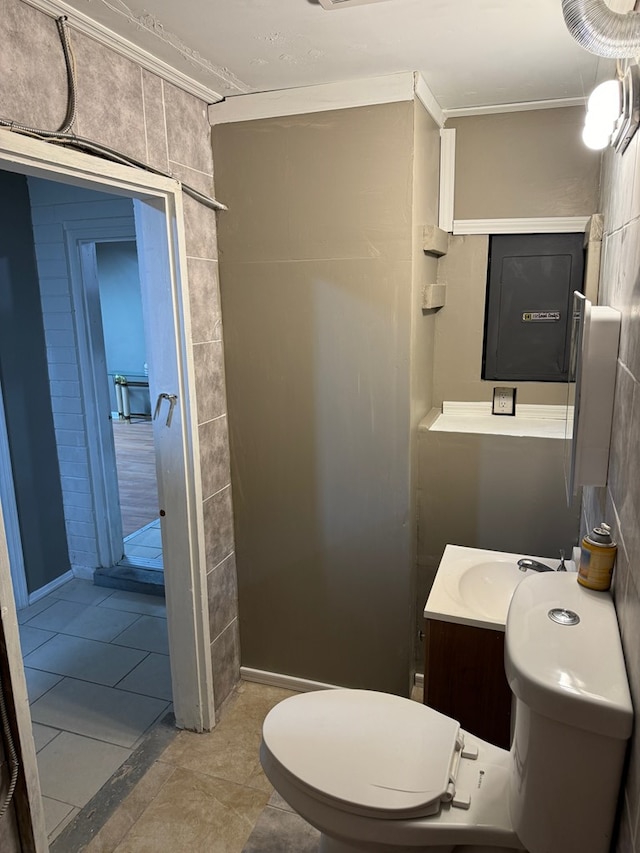 bathroom featuring toilet, vanity, crown molding, and tile patterned flooring