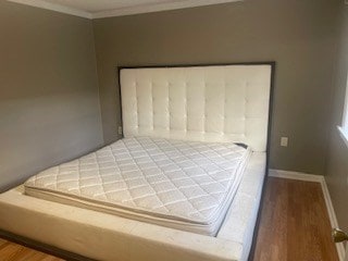 bedroom featuring wood-type flooring and crown molding