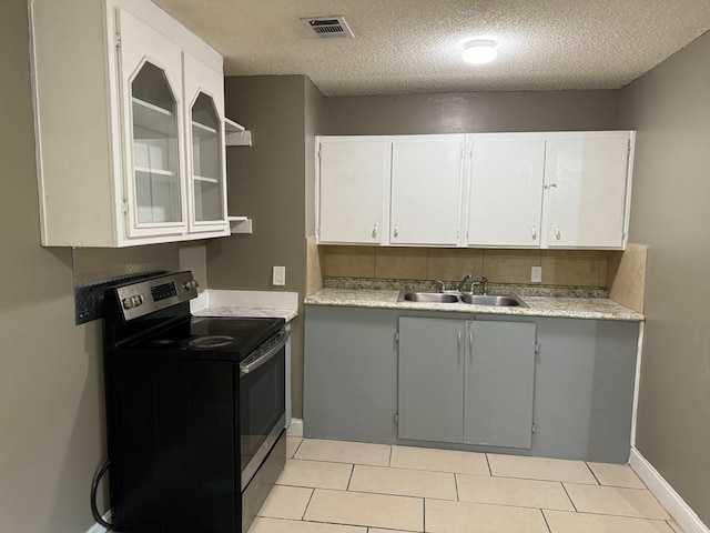 kitchen with sink, white cabinets, stainless steel range with electric cooktop, and a textured ceiling