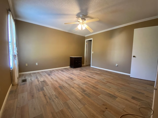 spare room featuring wood-type flooring, a textured ceiling, ceiling fan, and crown molding