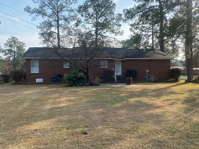 back of property featuring central AC and a lawn