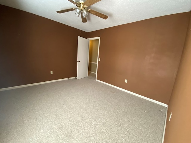 spare room with carpet, a textured ceiling, and ceiling fan