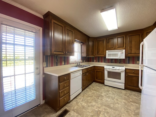 kitchen featuring sink, a textured ceiling, and white appliances