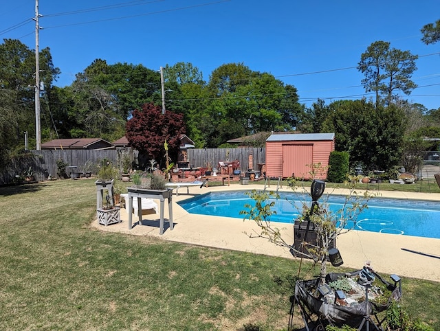 view of swimming pool with a lawn and a storage unit