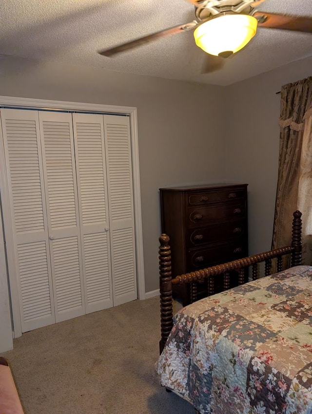 carpeted bedroom with a textured ceiling, a closet, and ceiling fan