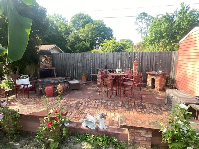 615 E 28th Ave, Cordele, GA 31015 - view of patio featuring an outdoor stone fireplace and a fenced backyard