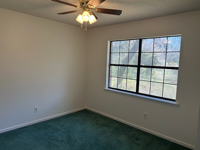 spare room with dark carpet, a textured ceiling, baseboards, and ceiling fan