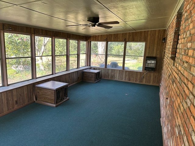 unfurnished sunroom with ceiling fan and heating unit