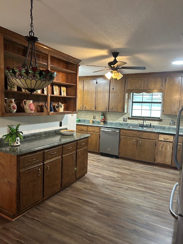 kitchen with a sink, appliances with stainless steel finishes, decorative backsplash, dark wood-style floors, and open shelves