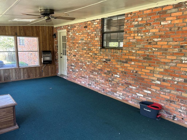 unfurnished sunroom with a ceiling fan and heating unit