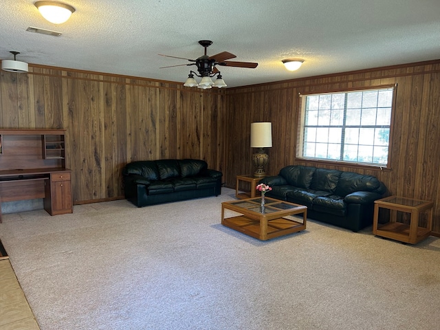 living room with crown molding, visible vents, light carpet, wooden walls, and a textured ceiling