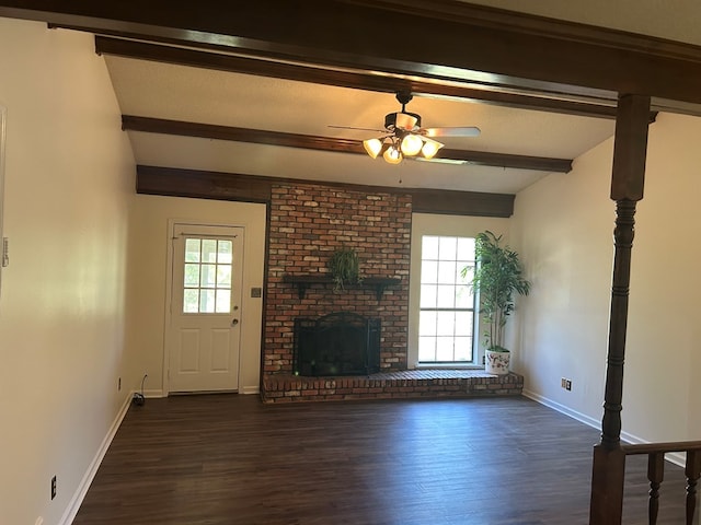 unfurnished living room featuring dark wood-type flooring, a brick fireplace, beamed ceiling, and baseboards