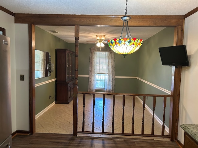 interior space with visible vents, baseboards, a textured ceiling, and tile patterned floors