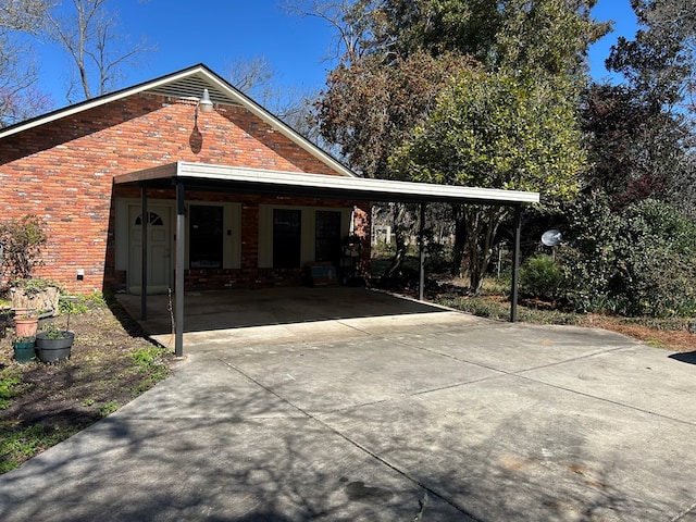 exterior space featuring an attached carport, concrete driveway, and brick siding