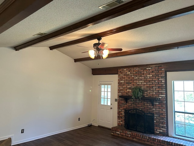 unfurnished living room featuring a textured ceiling, dark wood-type flooring, a fireplace, visible vents, and baseboards