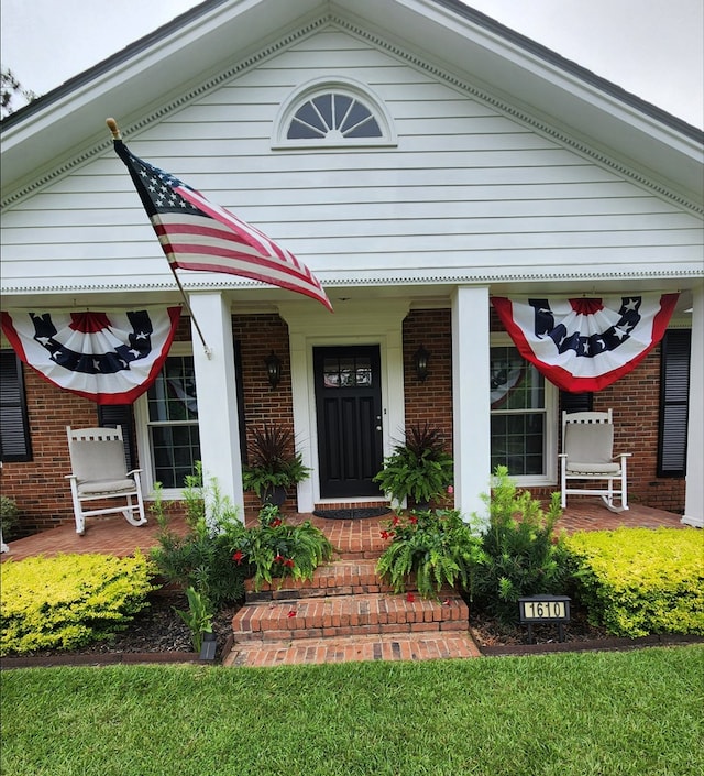 view of front facade featuring covered porch and brick siding