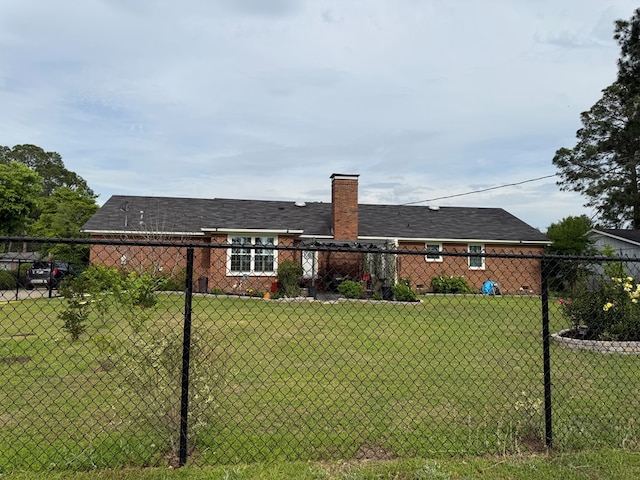 back of property featuring a yard, a chimney, and fence