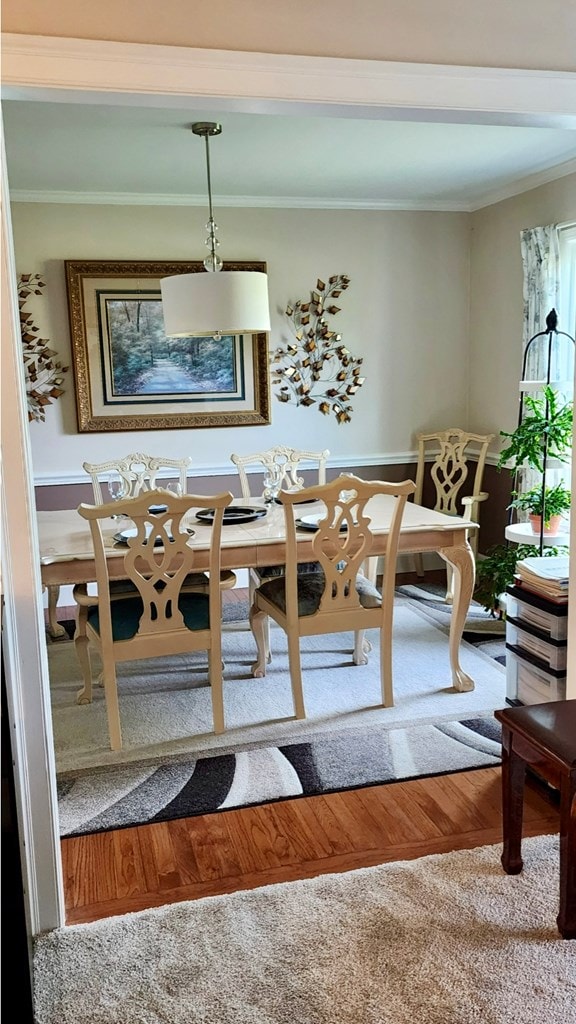 dining space featuring crown molding and wood finished floors