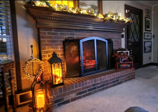 interior details featuring a brick fireplace and carpet