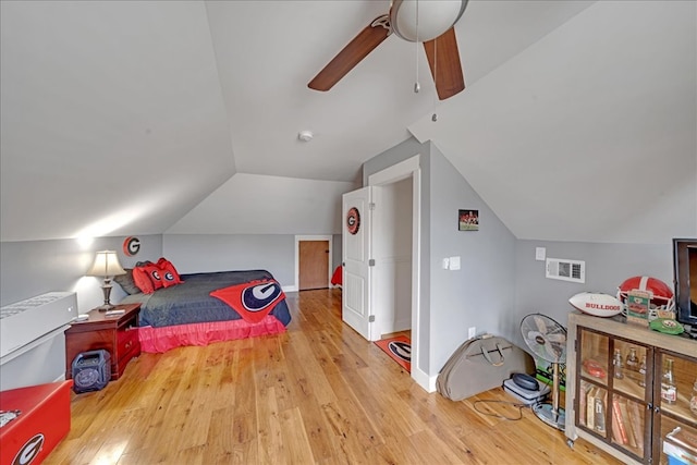 bedroom with ceiling fan, vaulted ceiling, and light hardwood / wood-style floors