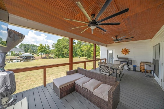 deck featuring ceiling fan, a yard, and an outdoor hangout area