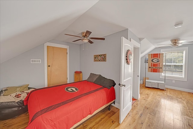 bedroom featuring ceiling fan, lofted ceiling, and light wood-type flooring