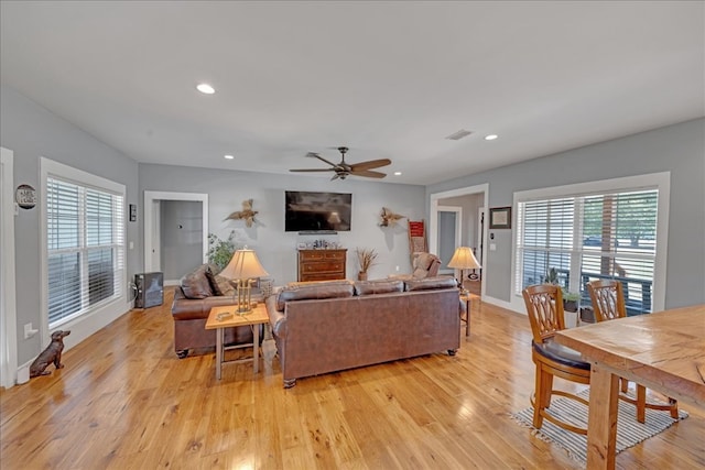 living room featuring a wealth of natural light, ceiling fan, and light wood-type flooring