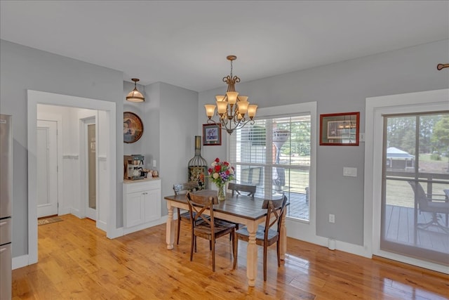 dining area featuring light hardwood / wood-style flooring and a chandelier