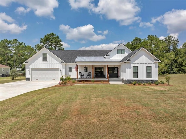 modern inspired farmhouse featuring a garage, a front yard, and covered porch