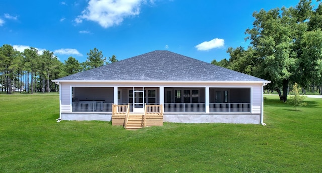 rear view of house with a yard and a sunroom