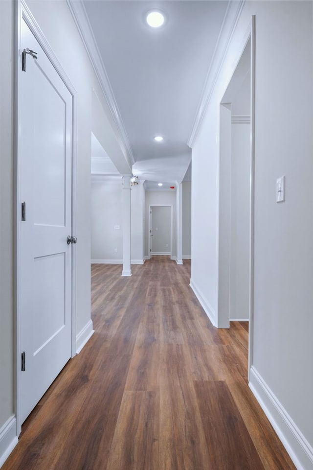 hall with dark wood-type flooring and ornamental molding