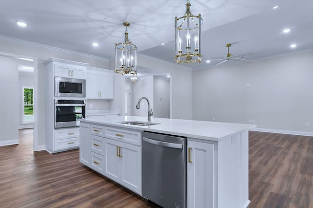 kitchen with sink, appliances with stainless steel finishes, white cabinetry, an island with sink, and decorative light fixtures