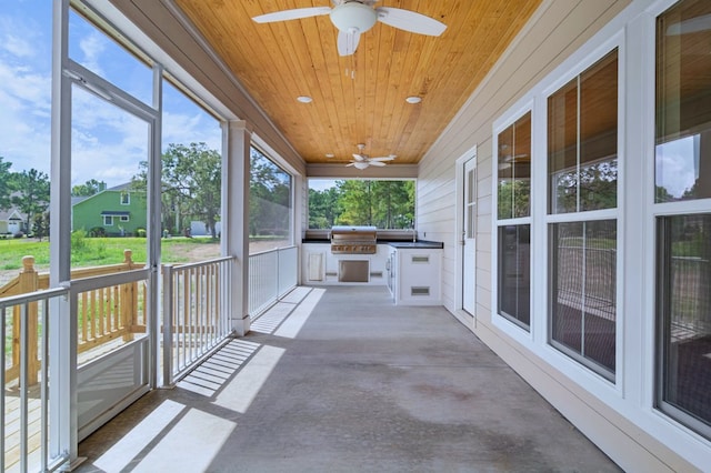 unfurnished sunroom featuring wooden ceiling and ceiling fan