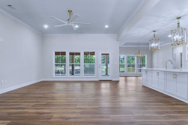 unfurnished living room featuring sink, ornamental molding, dark hardwood / wood-style floors, and ceiling fan with notable chandelier