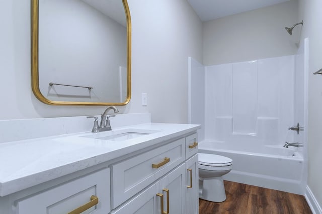 full bathroom with vanity, hardwood / wood-style floors, shower / bathtub combination, and toilet