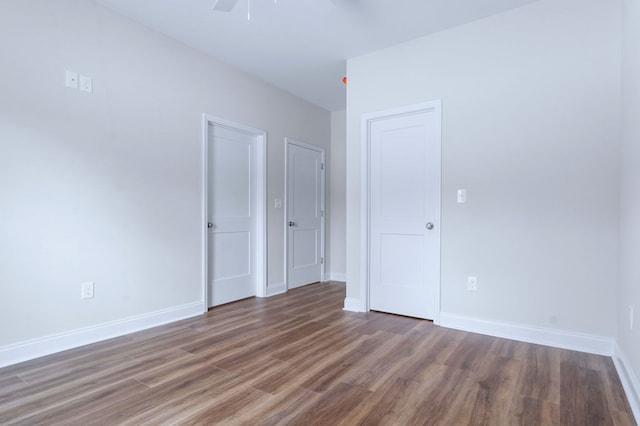 empty room with ceiling fan and dark hardwood / wood-style flooring