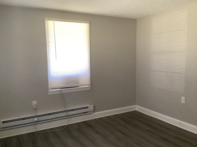 empty room with dark wood-style floors, baseboards, and baseboard heating