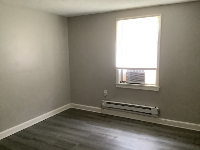 empty room featuring cooling unit, baseboards, a baseboard heating unit, and dark wood-style flooring