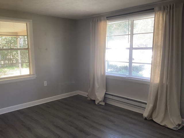 spare room with a healthy amount of sunlight, baseboards, and dark wood finished floors