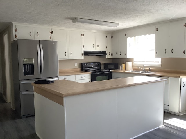 kitchen with black appliances, under cabinet range hood, white cabinets, and a sink